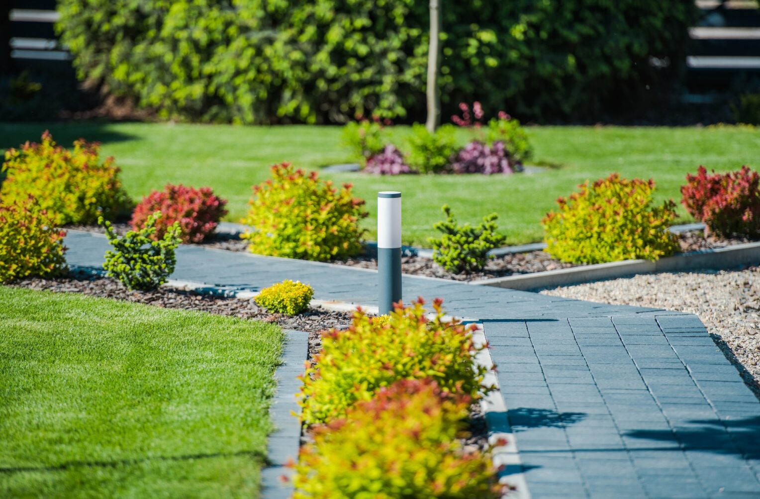 Gestalteter Garten mit Wegen, Rasen und Bepflanzung